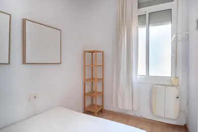 a white bedroom with a bed and a window at Charm and Comfort in the Heart of Sant Antoni, Barcelona in Barcelona