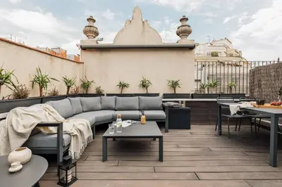 a rooftop patio with a couch and tables at Lura - 2 bedrooms and terrace in Eixample Esquerra in Barcelona