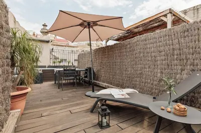 a patio with an umbrella and tables and chairs at Lura - 2 bedrooms and terrace in Eixample Esquerra in Barcelona
