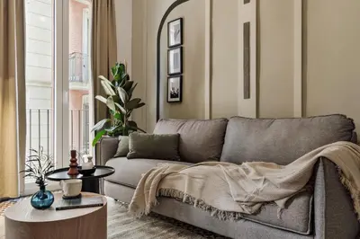 a living room with a chair and a tv at Tiqui - 1 bedroom and balcony in Vila de Gràcia in Barcelona
