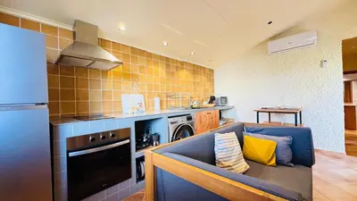 a kitchen with a blue couch and a stove at Apartament rural in San Martín Sarroca