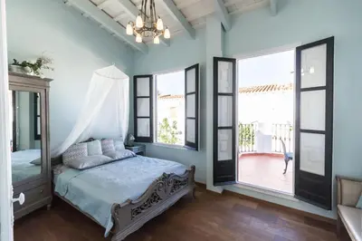 a bedroom with a bed with blue walls and windows at Traumhäuschen am Meer für 2, Barcelona in Vilassar de Mar