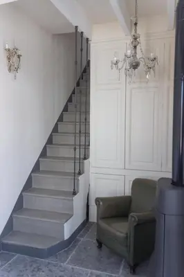 a staircase with a green chair and a chandelier at Traumhäuschen am Meer für 2, Barcelona in Vilassar de Mar