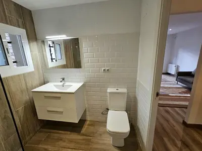 a bathroom with a white toilet and a sink at Poolside Apartment Barcelona Sant Cugat in Sant Cugat del Vallès