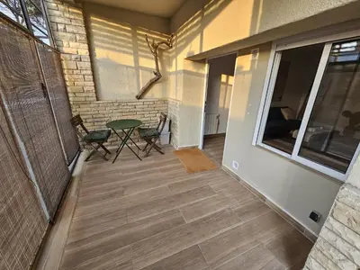 a patio with a table and chairs and a brick wall at Poolside Apartment Barcelona Sant Cugat in Sant Cugat del Vallès