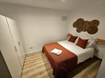 a bedroom with a large bed with brown pillows at Poolside Apartment Barcelona Sant Cugat in Sant Cugat del Vallès