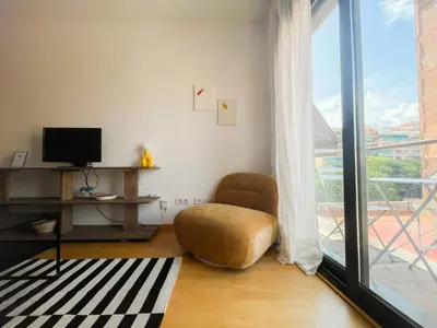 a living room with a chair and a window at Boutique Socors in Barcelona