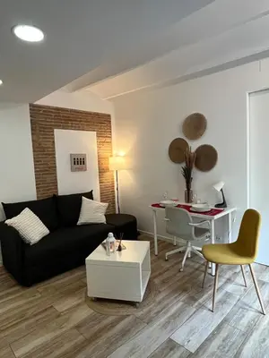 a living room with a black couch and a table at Barceloneta Love 1 min to the beach in Barcelona