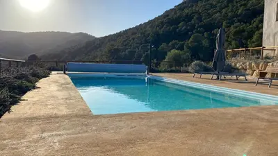 a swimming pool with a mountain in the background at Masia Cal Noia - Rural Villas in Castellví de la Marca