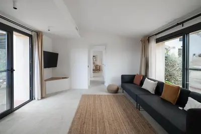 a living room with a blue couch and windows at Masia Cal Noia - Rural Villas in Castellví de la Marca
