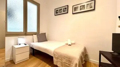 a small bedroom with a bed and a window at S4D Villarroel Clinic in Barcelona