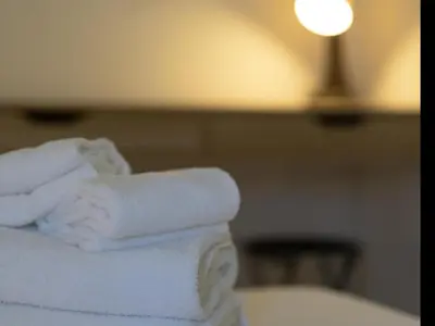 a pile of towels sitting on top of a bed at Winahost Barcelona Gracia in Barcelona