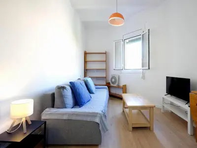 a living room with a couch and a tv at Winahost Barcelona Gracia in Barcelona