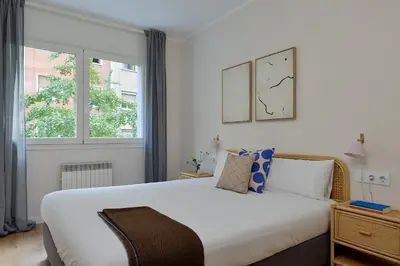 a bedroom with a large white bed and a window at Casa Cosi - Camp Nou in Barcelona
