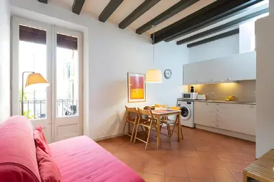 a living room with a table and a kitchen at Tranquil Cozy with balcony Plaça Catalunya. RI. in Barcelona