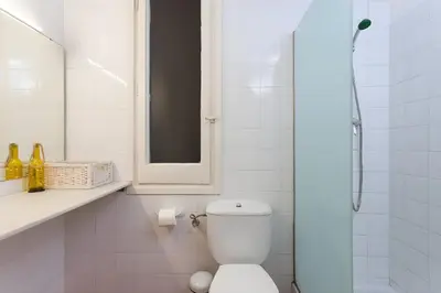 a white bathroom with a toilet and a shower at Tranquil Cozy with balcony Plaça Catalunya. RI. in Barcelona