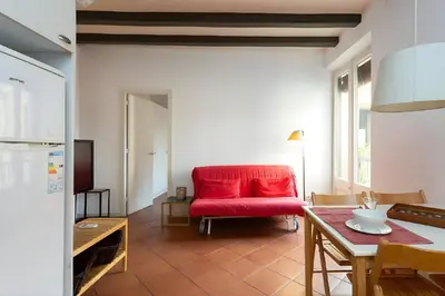 a living room with a red couch and a table at Tranquil Cozy with balcony Plaça Catalunya. RI. in Barcelona