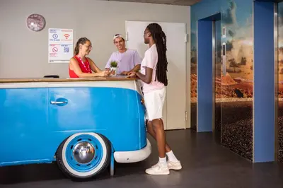 a group of people standing around a blue and white van at Urbany Hostel Barcelona in Barcelona