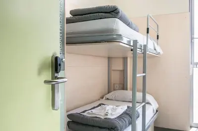 two bunk beds in a room with a door at Urbany Hostel Barcelona in Barcelona