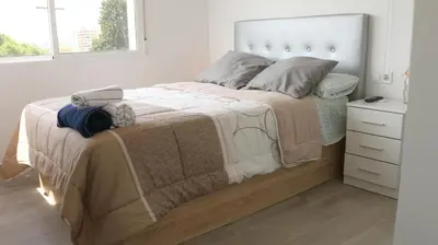 a white bedroom with a large bed and a dresser at El Barco Aparta Hotel in Hospitalet de Llobregat