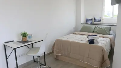 a small bedroom with a bed and a desk at El Barco Aparta Hotel in Hospitalet de Llobregat