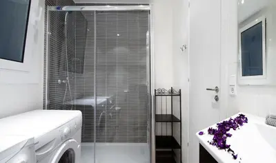 a white bathroom with a shower and a sink at Apartment Gaudi XL in Barcelona