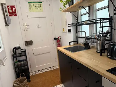 a kitchen with a sink next to a door at Vaganto Coliving in Barcelona