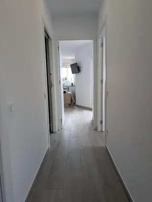 an empty hallway with white walls and a wooden floor at Apartament Hotel - El Barco in Hospitalet de Llobregat