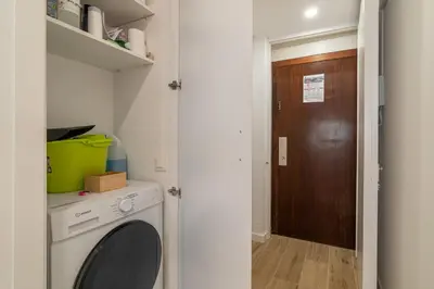 a laundry room with a washing machine and a wooden door at Stay Unique Apartment Taquigraf in Barcelona