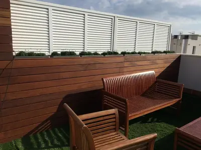 two wooden chairs and a bench on a balcony at Ático con vistas al mar, solarium privado y piscina in Sitges
