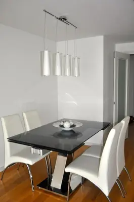 a dining room with a black table and white chairs at Ático con vistas al mar, solarium privado y piscina in Sitges