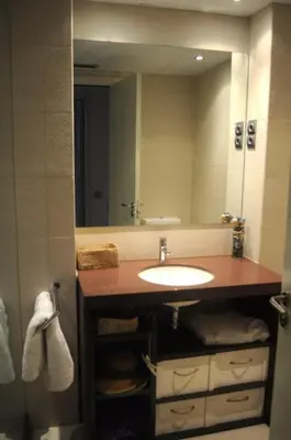 a bathroom with a sink and a large mirror at Ático con vistas al mar, solarium privado y piscina in Sitges