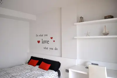 a bedroom with a bed with red pillows at Ático con vistas al mar, solarium privado y piscina in Sitges
