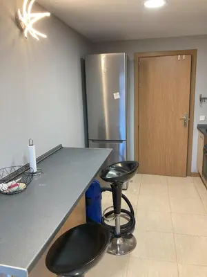 a kitchen with a counter with two stools and a refrigerator at Fantastic apartment in Barberà in Barbera del Valles