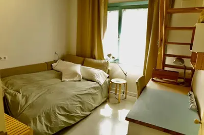 a bed in a room with a window and a bed sidx sidx sidx at Independent duplex in a stately villa in Sant Cugat del Vallès