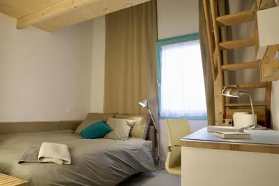 a bedroom with a bed with a desk and a window at Independent duplex in a stately villa in Sant Cugat del Vallès