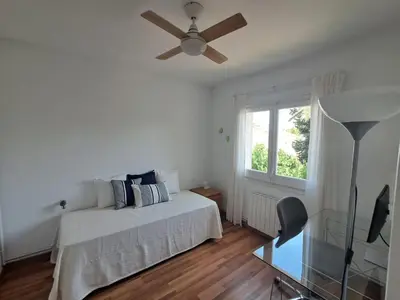 a bedroom with a bed and a ceiling fan at Quiet cozy apartment near beach in Sitges