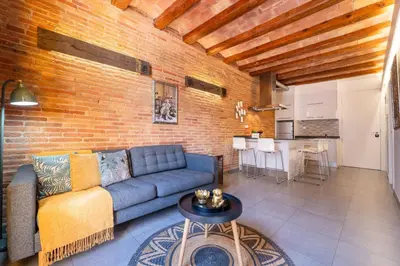 a living room with a blue couch and a brick wall at Sweett - Gallery Poble Sec in Barcelona