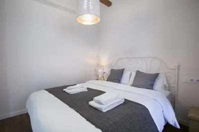 a bedroom with a white bed with towels on it at Tendency Apartments - Sagrada Familia in Barcelona