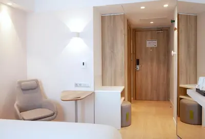 a room with a bed and a chair and a door at Holiday Inn Express & Suites Barcelona - Sabadell by IHG in Sabadell