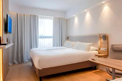a hotel room with a large bed and a desk at Holiday Inn Express & Suites Barcelona - Sabadell by IHG in Sabadell