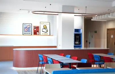 a restaurant with tables and chairs and a counter at Holiday Inn Express & Suites Barcelona - Sabadell by IHG in Sabadell
