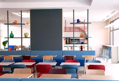 a restaurant with blue and red chairs and tables at Holiday Inn Express & Suites Barcelona - Sabadell by IHG in Sabadell