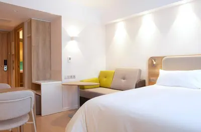 a hotel room with a bed and a couch at Holiday Inn Express & Suites Barcelona - Sabadell by IHG in Sabadell