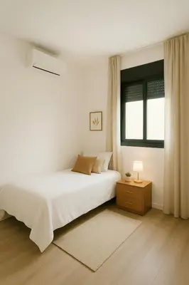 a white bedroom with a bed and a window at D&G casas in El Prat de Llobregat