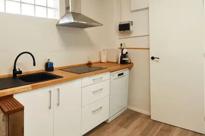 a kitchen with white cabinets and a sink and a refrigerator at Casa en Sierra Collserola in Sant Cugat del Vallès