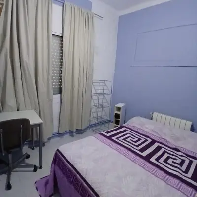 a bedroom with a bed and a desk and a window at Habitación azul con cama doble disponible en Barcelona in Barcelona