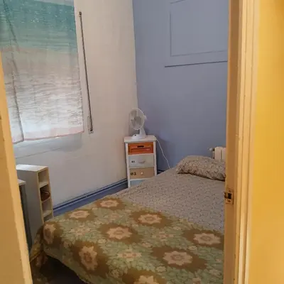 a small bedroom with a bed and a window at Habitación azul con cama doble disponible en Barcelona in Barcelona