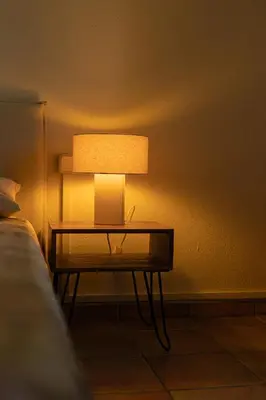 a table with a lamp on a wall next to a bed at Estudio con encanto en Barcelona in Barcelona