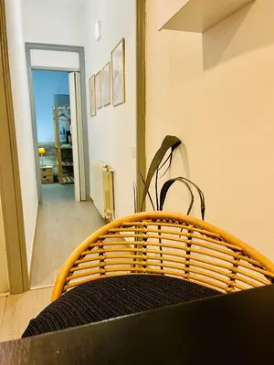 a rattan bench in a room with a hallway at Basic interior Apartment Sagrada Familia Excellent for exploring Barcelona Very good location in Barcelona